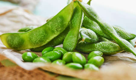 Edamame or soybeans on brown paper on brown sackcloth.の写真素材