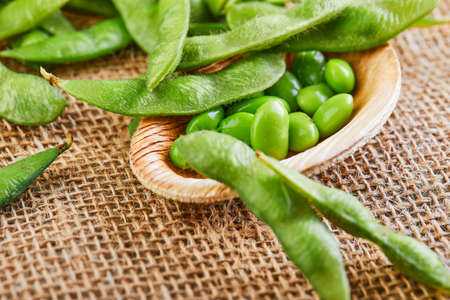 Edamame or soybeans in a wooden plate on a brown sackcloth.の写真素材