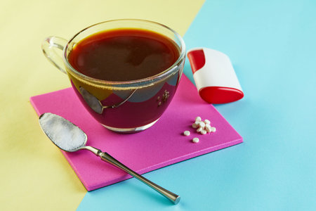 Cup of coffee and Pills of sugar substitute and natural sweetener in powder on a purple podium.の写真素材