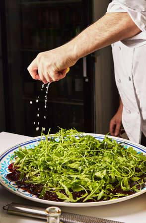Beet carpaccio. Chef pours lemon on beetroot carpaccio with sauce and herbs.の写真素材