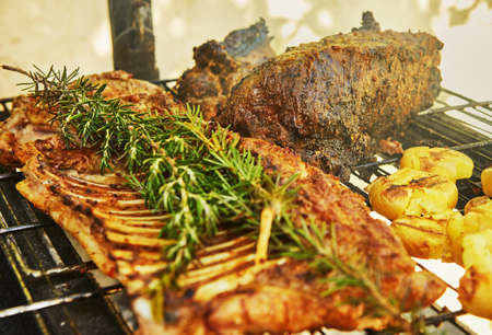 Slow-smoked lamb ribs on the grill with rosmarine.の写真素材