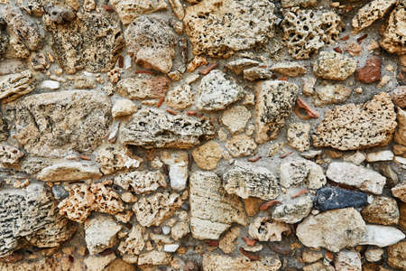 Background of the stone wall of the castle made of stones of different shapes and sizes and textures.の写真素材