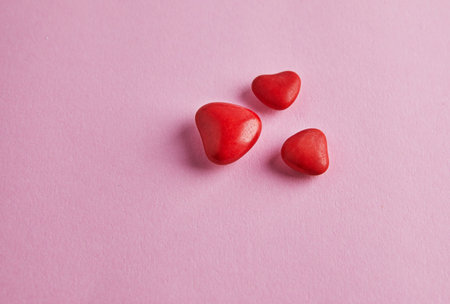 Valentine's day banner with candy hearts on pink background. Top view with a place for your...