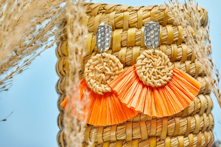 Natural handmade product, a pair of earrings on the background of Golden reed grass. Eco-friendly...