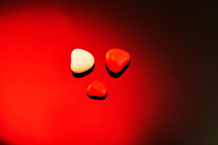 Valentine's Day candies on red black background. Red candy hearts with space for text.の写真素材