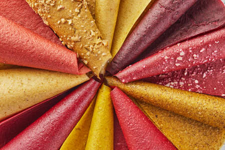 Sweet pure fruit pastille in rolls. Healthy sweets - lozenges, fruit chips. Natural sweets from berries and fruits. Diet vitamin food and vegan food. Flat lay. Close upの写真素材