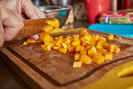 Cooking at home in the kitchen according to recipe from the Internet. Woman cuts dalorit to make...