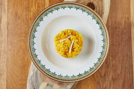 Risotto, ready-made portion of step-by-step recipe in a vintage plate on a wooden background. Flat layの写真素材