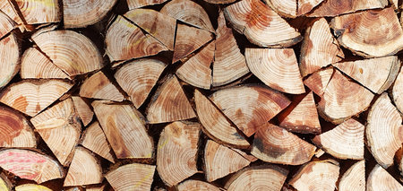 Background texture from chopped quarters of firewood stacked together.