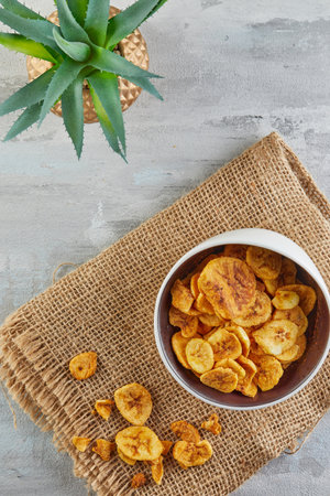 Banana chips healthy food, dry fruits and healthy vegetable chips, healthy vegan snacks on burlap and aloe flowerの写真素材