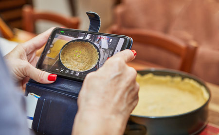 Woman shoots video on mobile phone mold for making cheese cake, step-by-step recipe from the...