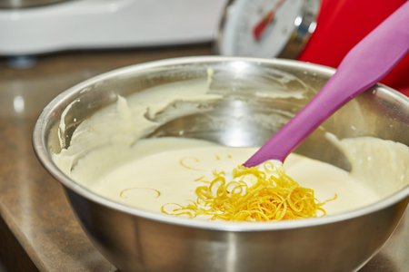 Woman stirring dough with spatula to make cheese pie with zest, step by step recipe from the...