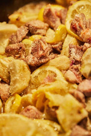 Lamb with lemon, artichokes and coriander stalks are fried over low heat in cauldron.の写真素材