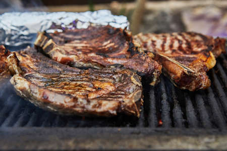Grilled beef steaks with grill smoke. BBQ party.の写真素材