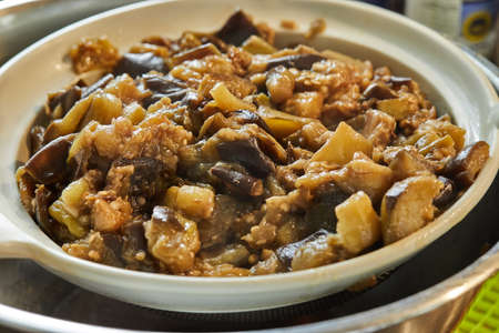 Oven-fried eggplants settle in sieve on a bowl. Close upの写真素材