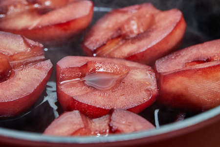 Cut pears are boiled in red syrup with wine on gas stoveの写真素材