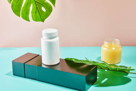 Mockup of jars and candles on the podium with monstera leaves.の写真素材
