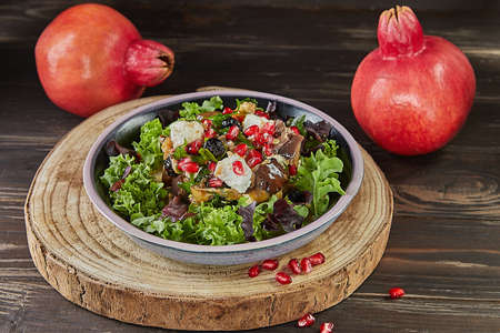 Eggplant salad with feta cheese, pomegranate and currants in a coffee marinade with pomegranates on the background. French gourmet cuisine.の写真素材