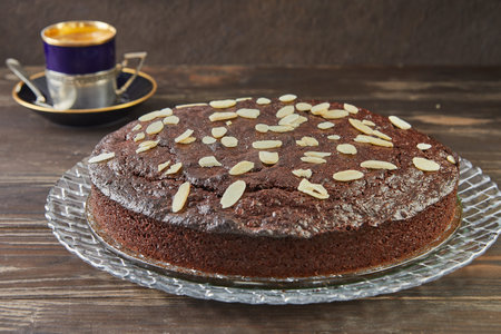 Autumn brownie pie with walnuts and chocolate. Cup of coffee on the background. French gourmet...