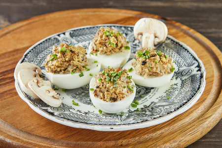Stuffed Mimosa eggs with mushrooms in vintage plate. French gourmet cuisineの写真素材