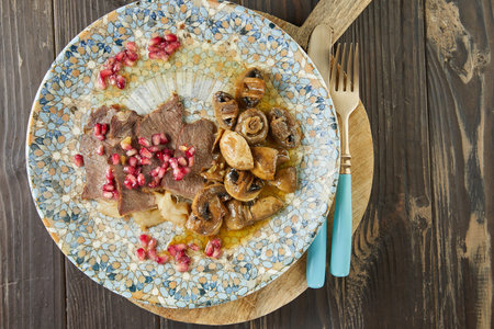 Roast beef with mushrooms and pomegranate seeds. French gourmet cuisineの写真素材