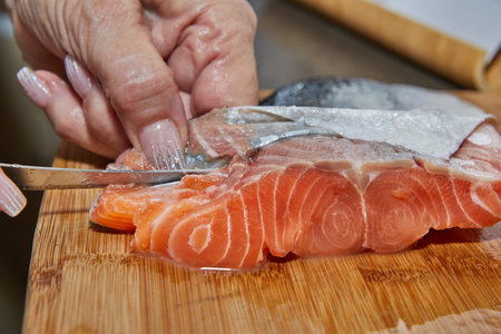 Chef is skinning salmon fillets for cookingの写真素材
