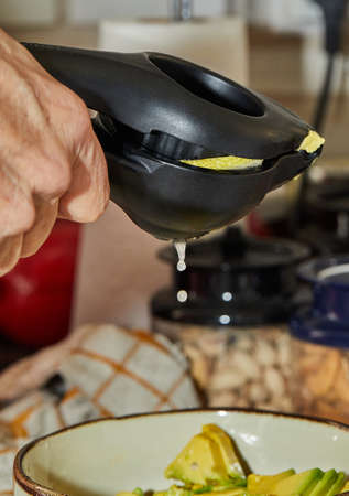 Cook squeezes lemon juice into salad using a special device for preparing saladの写真素材
