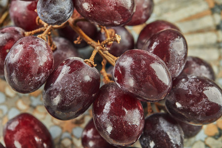 Fresh grapes with water droplets on plate, ready to eat.