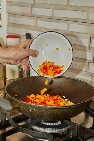 Add red and yellow bell peppers to pan to make the dish.