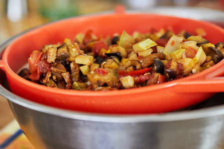 Sieve with eggplant, zucchini and bell pepper in close-up.の写真素材