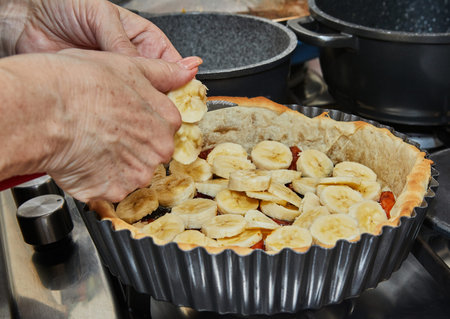 Cooking Winter cake With apricots, plums, bananas and pineapple. French gourmet cuisine.