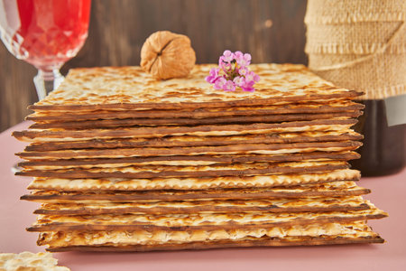 Pesach celebration concept - Jewish Passover holiday. Stack of matzah, bottle of wine with glass and...