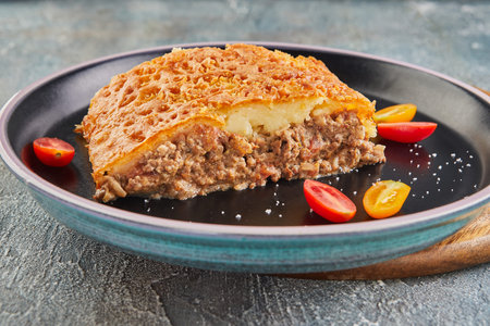 Pie with beef Tourtiere and cherry tomatoes. Pie with minced meat.
