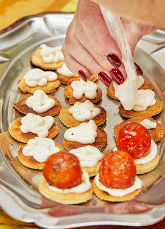 Chef lays out cherry tomatoes for the Ricotta Starter on tray.