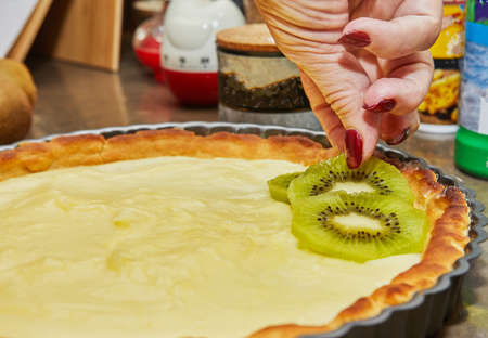 Chef prepares kiwi pie by spreading the kiwi in circle.の写真素材