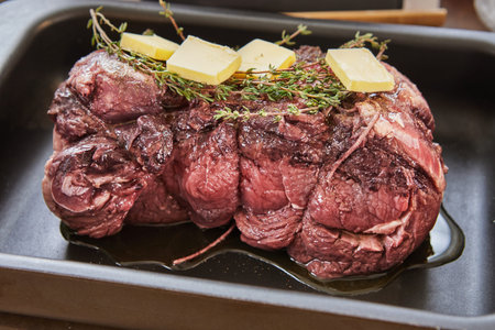 Beef with rosemary and butter is ready for baking in the oven