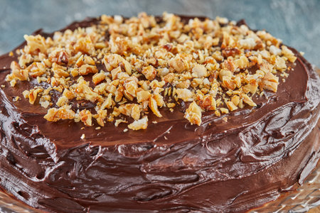 Chocolate pie with pear and walnuts on wooden stand. close up.