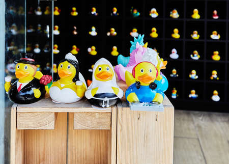 Rubber ducks stand on black shelves in different shapes and colorsの写真素材