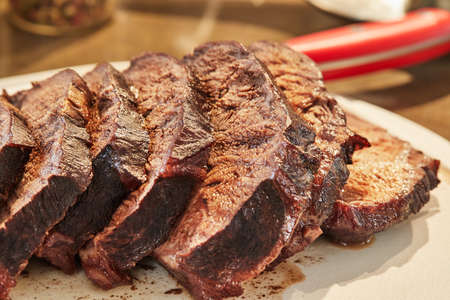 Sliced pieces of beef, fried with onions in wine sauce, ready to serve on board. French gourmet cuisine.の写真素材