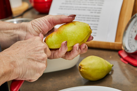 Chef cuts the pears into slices for chocolate cake with pear and nuts. Step by step recipeの写真素材