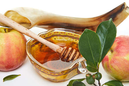 Rosh hashanah - jewish new year holiday concept. An apple-shaped bowl with honey, apples, a shofar are traditional symbols of the holiday. isolated on white background.の写真素材
