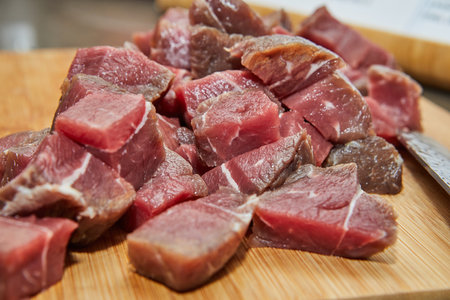 Chef cuts the beef meat into cubes for cookingの写真素材