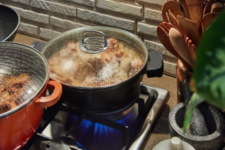Pots with cooking food in the kitchen on gas stoveの写真素材