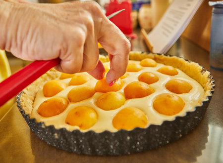 Chef puts apricots in pie to bake in the ovenの写真素材