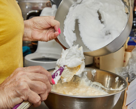 Chef adds whipped egg whites to the pie dough in the bowl.の写真素材