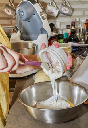 Chef adds creme fraiche to bowl of pie ingredients.