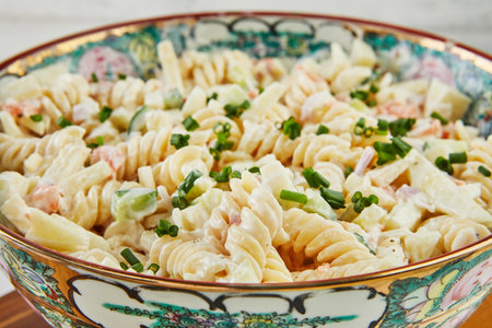 Fusilli salad with shrimp and green onions in colored bowlの写真素材