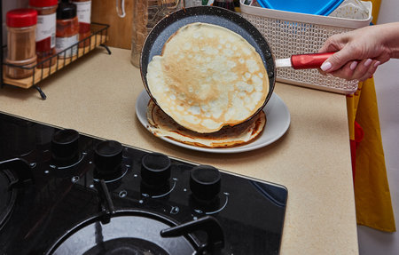 Cooking Crepe Suzette pancakes in frying pan on gas stove.の写真素材