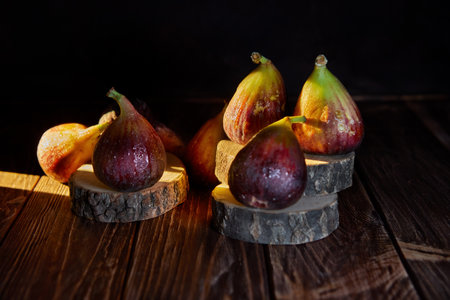 Figs on wooden background and wooden stands with hard shadows.の写真素材