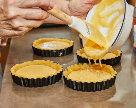 Pour the batter into small round molds to make cherry pieの写真素材